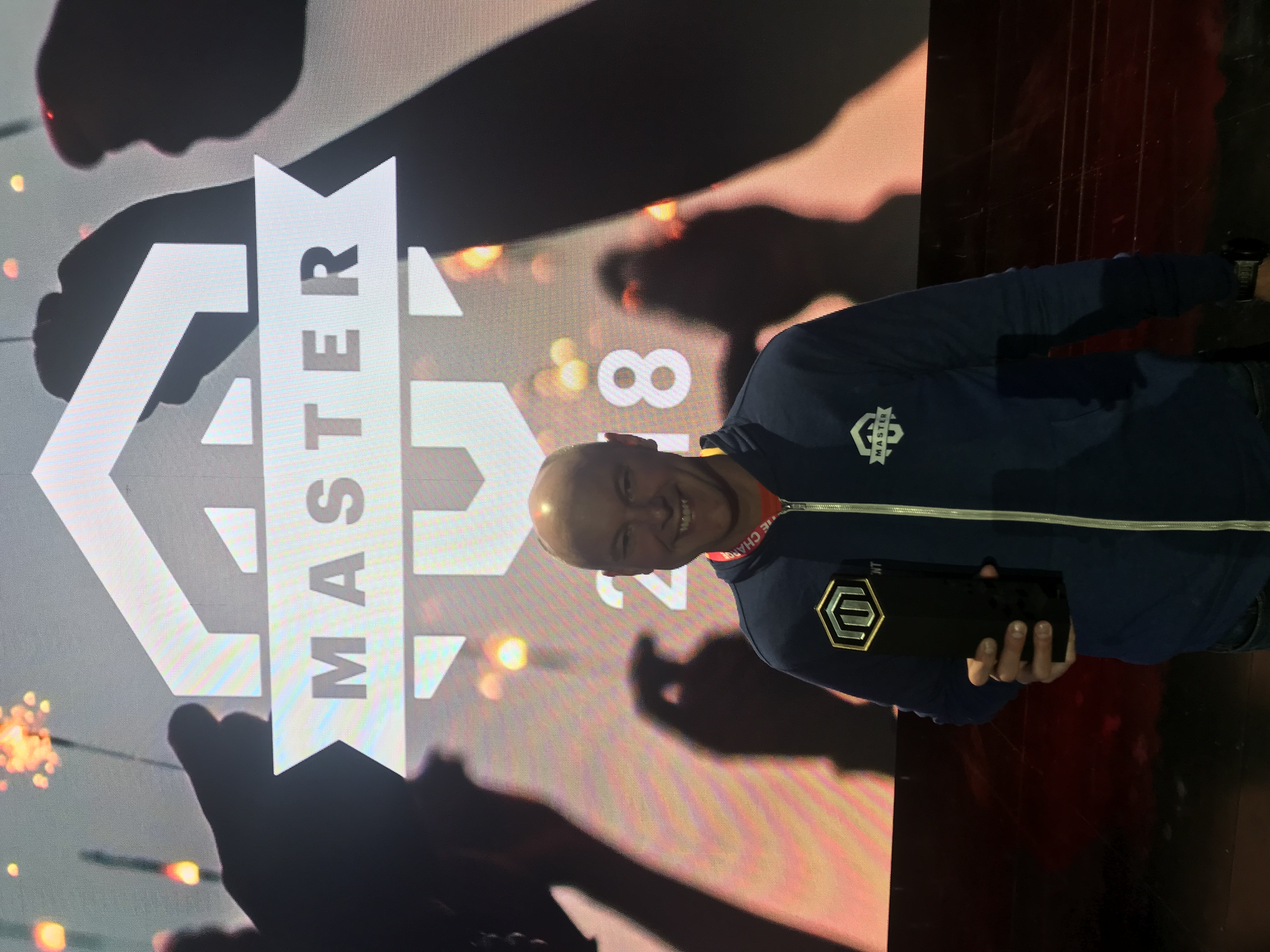 Brent Peterson in front of the Magento Master 2018 badge on the big screen at Imagine